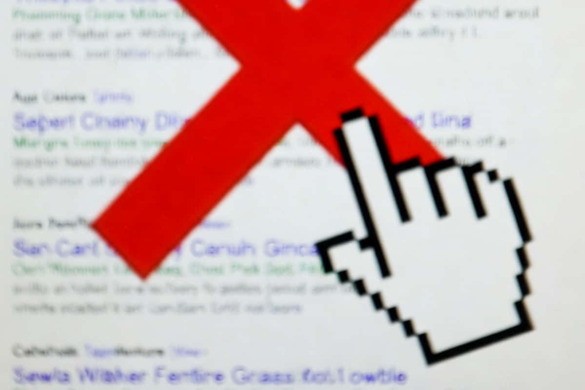 Gros plan sur un grand X rouge superposé sur un texte flou et illisible en arrière-plan, symbolisant une erreur, une suppression ou une interdiction.